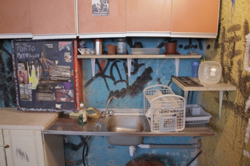 ο χώρος της κουζίνας με τα ντουλάπια που περιέχουν πιάτα, κατσαρόλες κτλ